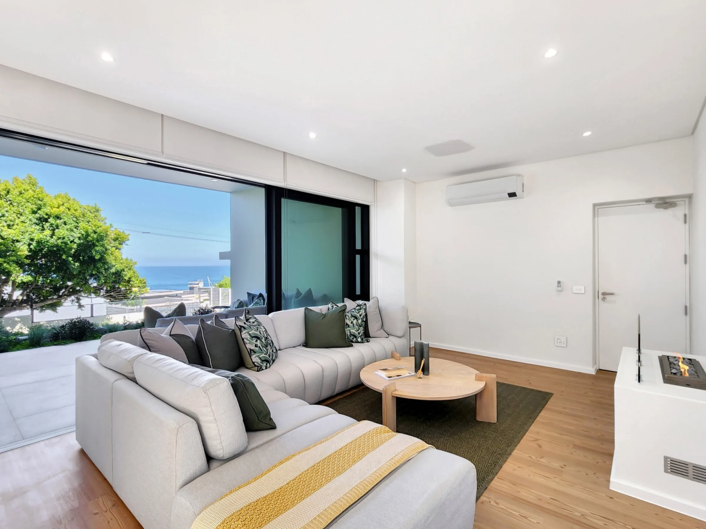 Ground-floor lounge with a fireplace and sea-facing patio access