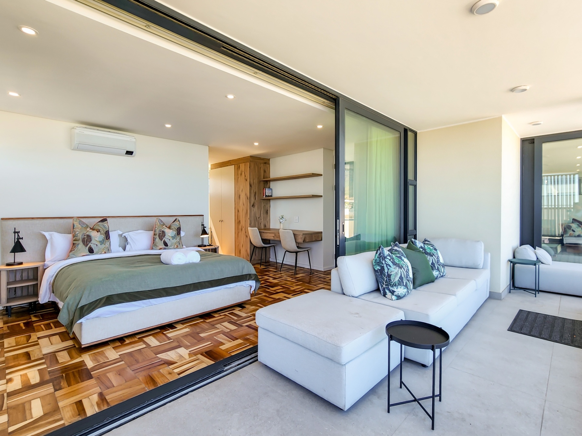 Master suite with King XL bed, workspace, and sliding doors to a private patio