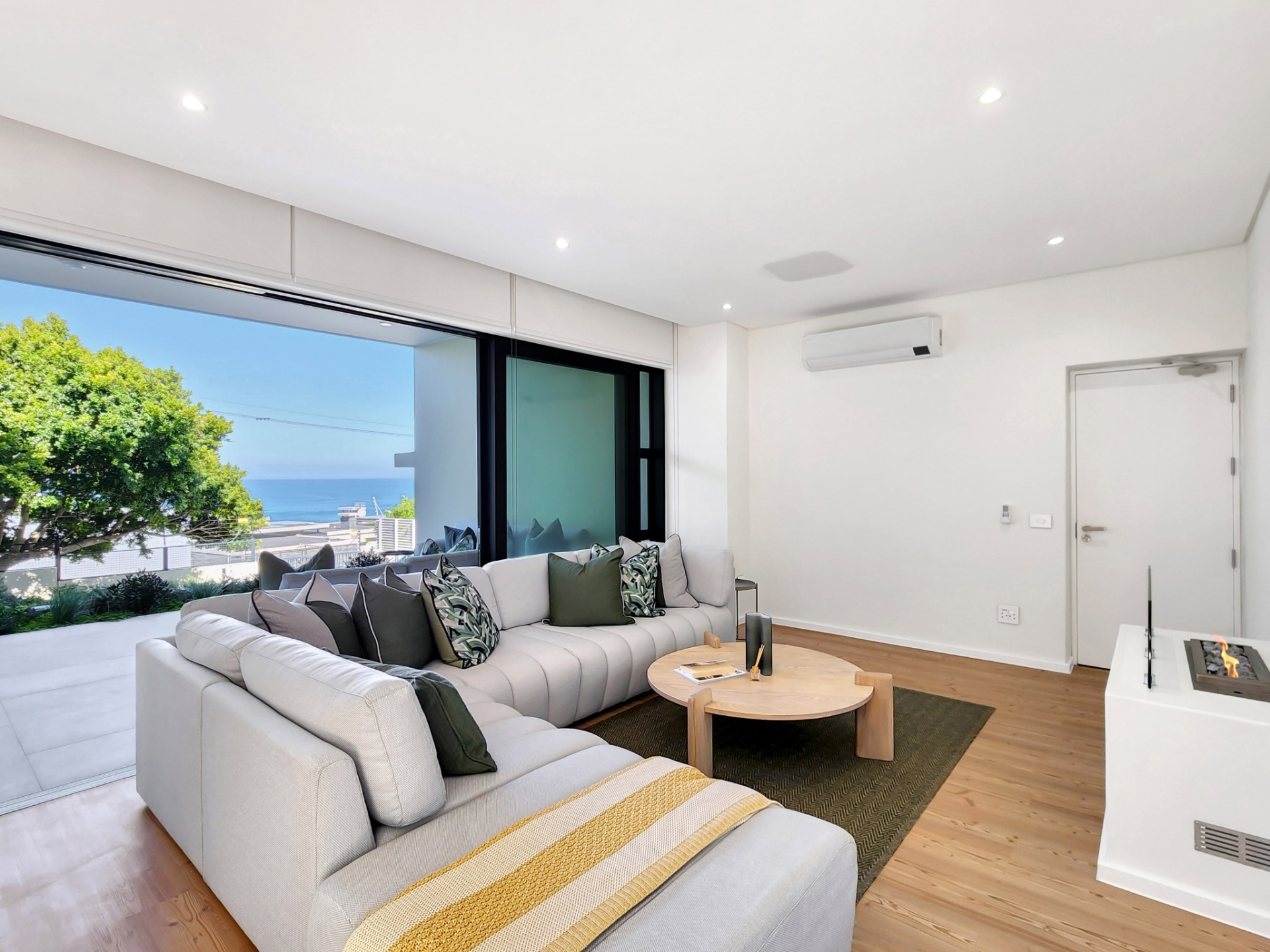 Ground-floor lounge with a fireplace and sea-facing patio access